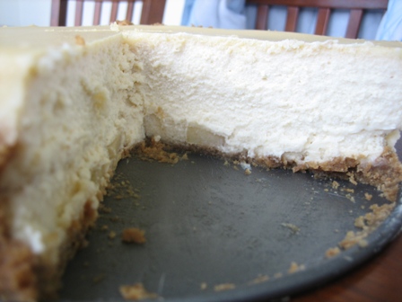 Brown sugar apple cheesecake on a metal pan with a slice removed showing the interior texture.