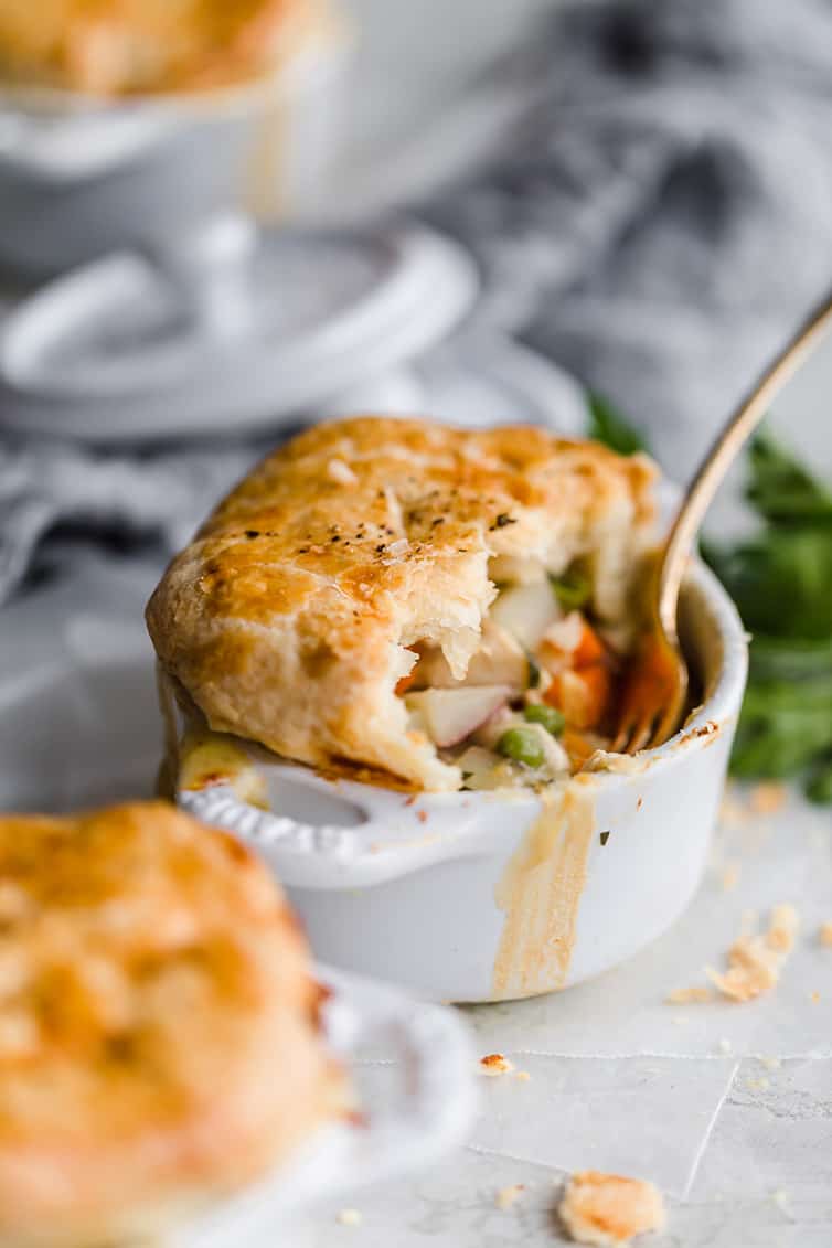 Chicken pot pie in a ramekin with half eaten.