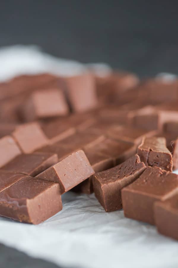 Squares of chocolate fudge on parchment paper.