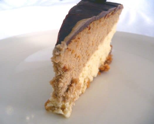 Slice of coffee and espresso layered cheesecake on a white plate.