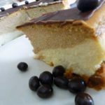 Slice of coffee and espresso layered cheesecake on a white plate.