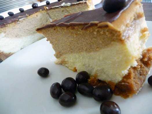 Slice of coffee and espresso layered cheesecake on a white plate.