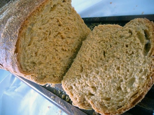 Loaf of anadama bread with a slice removed showing the inside texture.