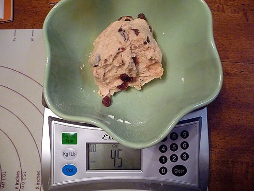 Green bowl with a scoop of ice cream in it on a food scale.