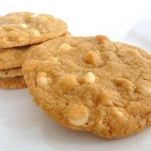 5 white chocolate macadamia nut cookies on a white plate.