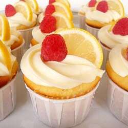 Lemon cupcakes topped with lemon frosting, a lemon slice, and raspberry.
