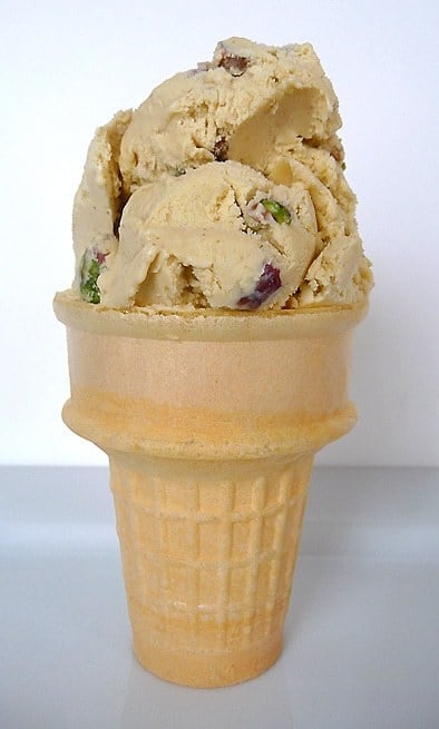 Ice cream cone topped with 2 scoops of pistachio nut ice cream.