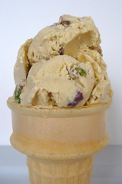 Ice cream cone topped with 2 scoops of pistachio nut ice cream.