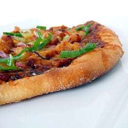BBQ chicken pizza on a white plate.