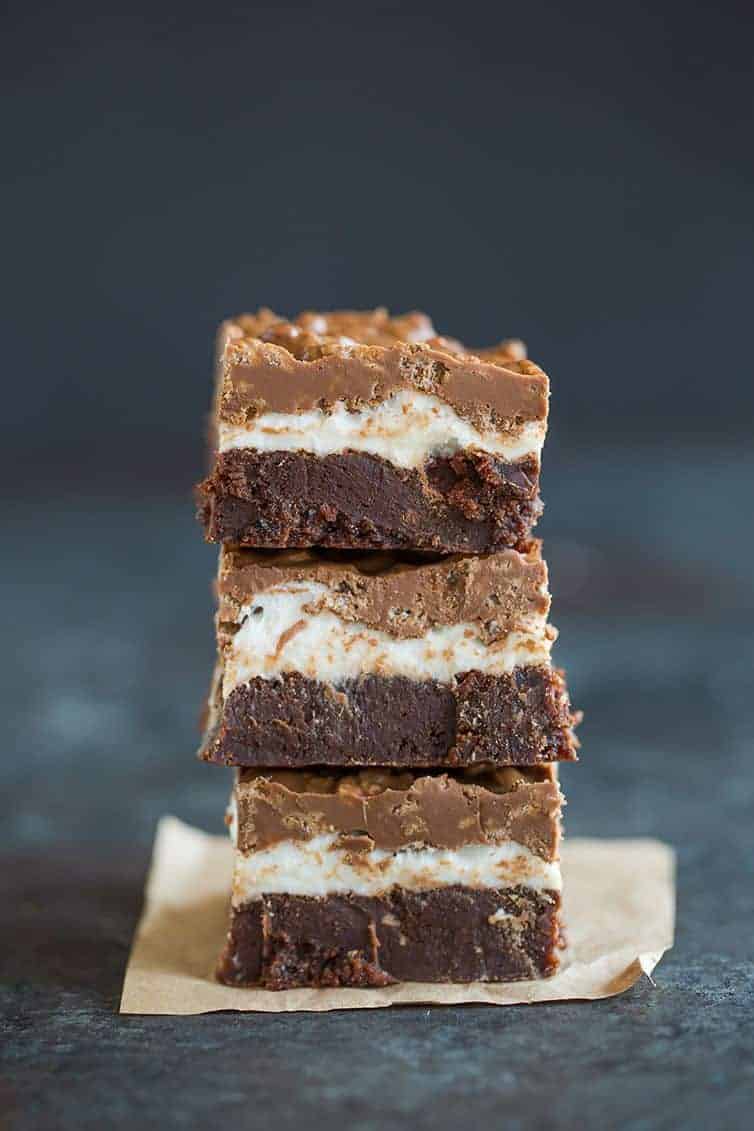 Marshmallow Crunch Brownie Bars - A stack of brownies with a layer of marshmallows and crisp chocolate and peanut butter topping.