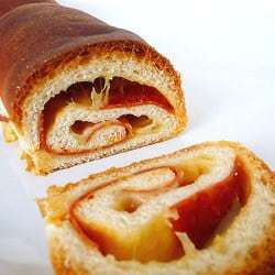 Swirled cheese and pepperoni bread with a slice cut showing the inside.