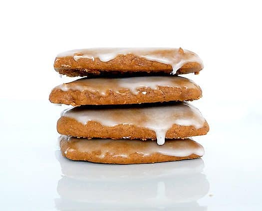 Stack of 4 glazed lebkuchen cookies on a white plate.