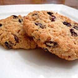 2 oatmeal raisin cookies on a white plate.