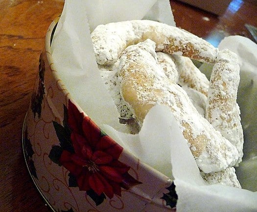 Nut crescent cookies in a cookie tin.