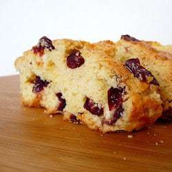 2 slices of cranberry white chocolate almond biscotti on a counter.