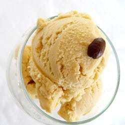 Scoops of espresso ice cream in a glass bowl topped with an espresso bean.