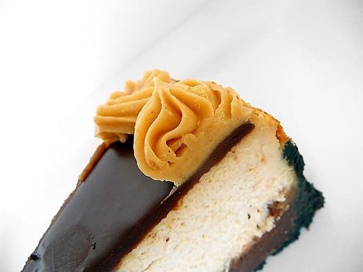 Slice of peanut butter fudge cheesecake on a white plate.