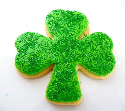 Shamrock sugar cookie with green icing and green sprinkles.