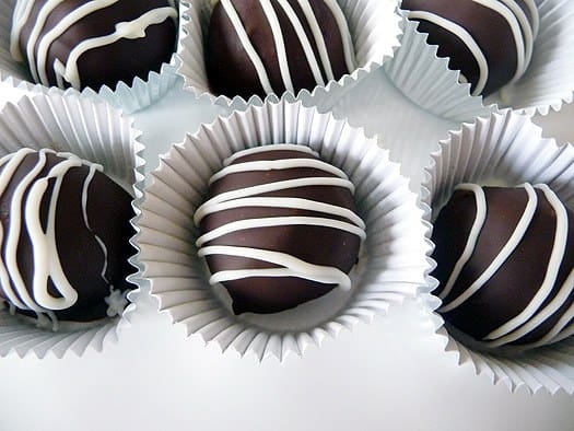 6 dark chocolate truffles in parchment candy liners.