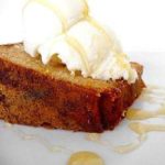 Slice of honey vanilla sour cream pound cake topped with vanilla ice cream and a drizzle of honey.