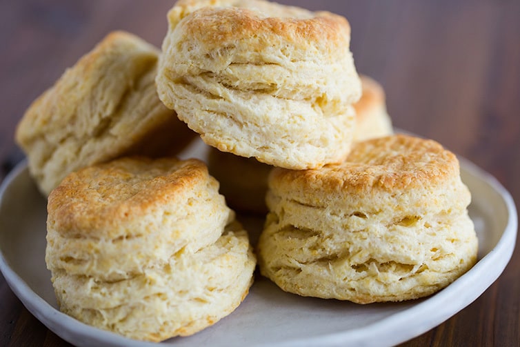A plate of tall, flaky buttermilk biscuits.