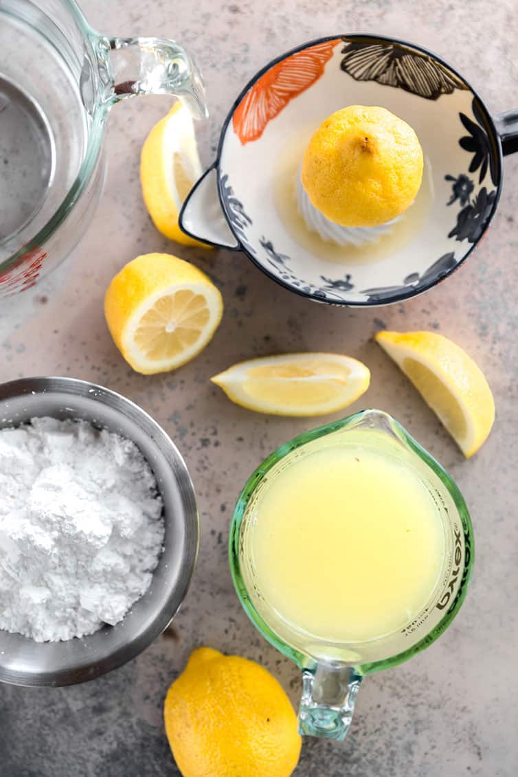 Sugar, lemon juice, and lemons prepped for lemonade.