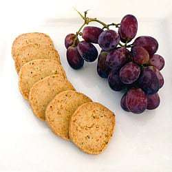 Parmesan and thyme crackers on a plate with grapes.