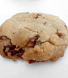 Pecan sandie cookie on a white plate.