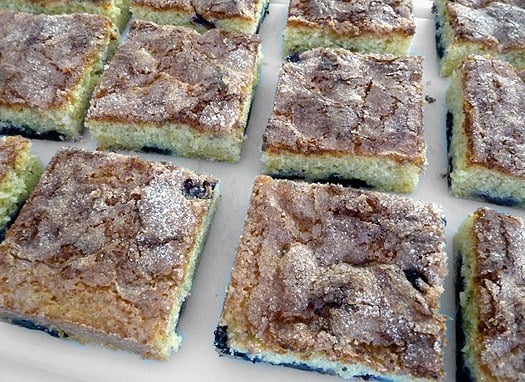 Squares of blueberry butter cake on a serving platter.