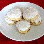 Frosted anise cookies on a white plate.