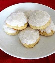 Frosted anise cookies on a white plate.