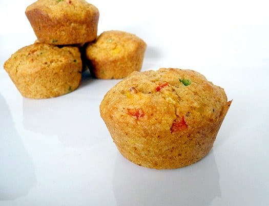 Corn muffins with peppers on a white plate.