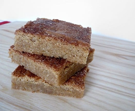 Stack of 3 snickerdoodle blondies on a wood surface.