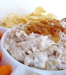 French onion dip topped with sautéed onions in a white bowl.