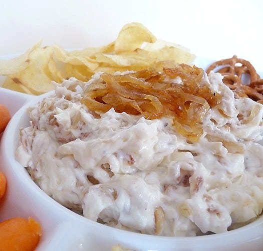 French onion dip topped with sautéed onions in a white bowl.