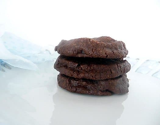 Stack of 3 salted chocolate shortbread cookies on a white plate.
