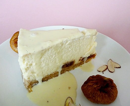 Slice of fig and almond cheesecake on a white plate.