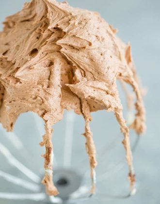 Stand mixer whisk attachment with a ton of chocolate frosting.