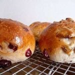 Side view of cranberry walnut rolls on a cooling rack.