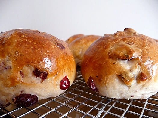 Side view of cranberry walnut rolls on a cooling rack.