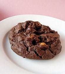 A salted double chocolate peanut butter cookie on a white plate.