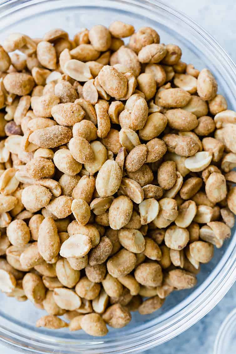 A bowl of salted, roasted peanuts.