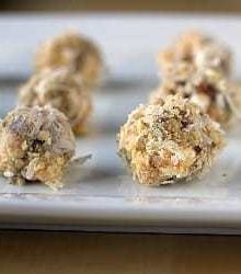 Date, coconut, and walnut truffles on a ceramic serving tray.