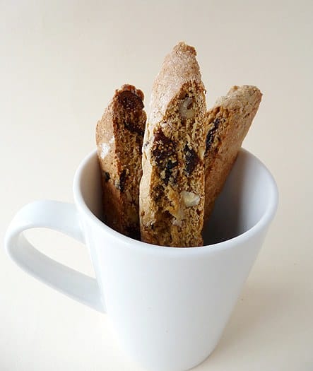 Fig and walnut biscotti in a white mug.