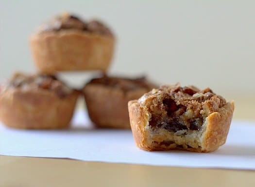 Pecan tassies with a bite taken from one.