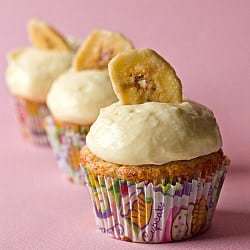 Banana cupcakes topped with vanilla pastry cream and a banana chip.