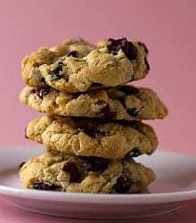 Stack of 4 cranberry white chocolate chip cookies on a white plate.