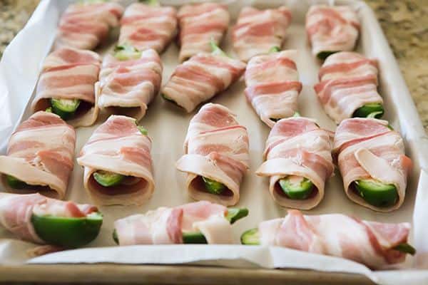 Jalapeno Poppers - A classic! Just three ingredients and super easy - halved, seeded jalapeños are stuffed with cream cheese and wrapped with bacon.
