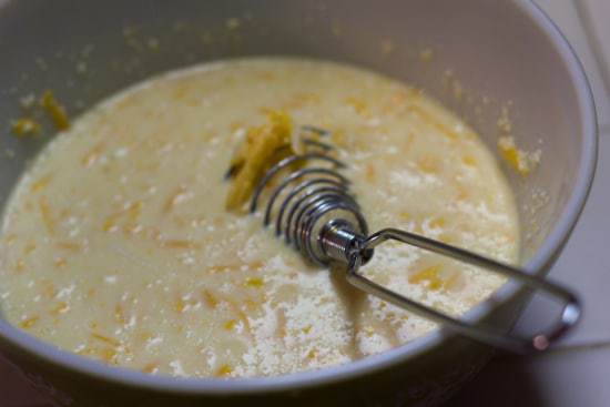 Cheese sauce in a saucepan with a whisk.