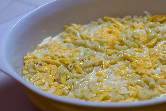 Noodles and cheese mixture spread into a baking dish before baking.